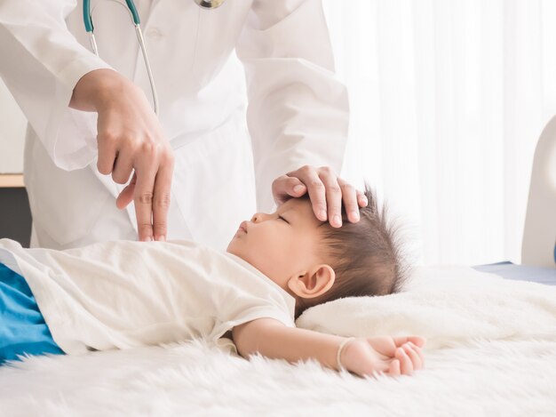 O médico deve usar os dedos para pressionar o peito da criança para demonstrar os procedimentos de rcp. Foto Premium