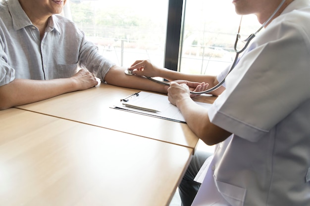 O médico mediu a pressão do paciente com um manômetro. Foto Premium