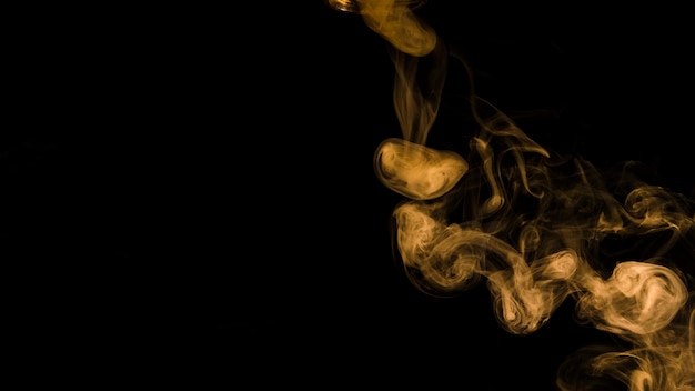 Onda amarela do fumo no fundo preto com espaço da cópia para escrever o texto Foto gratuita