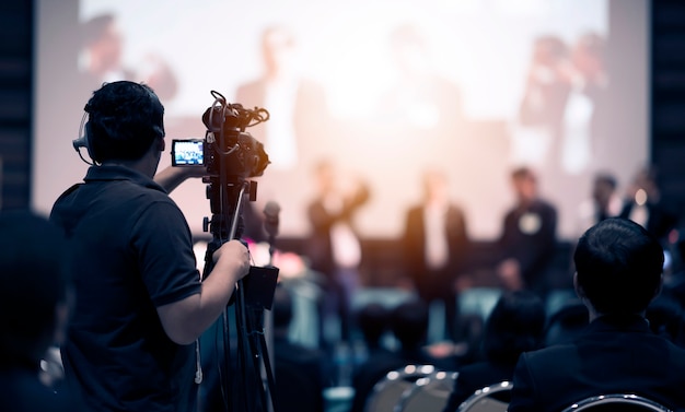 Operador de câmera de vídeo trabalhando com seu equipamento no evento indoor Foto Premium