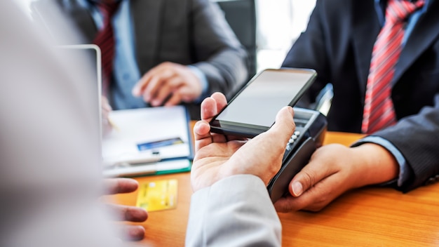 Os clientes que pagam fatura dinheiro rápido financeiro por tecnologia de pos pagamento nfc com aplicativo móvel no smartphone. Foto Premium