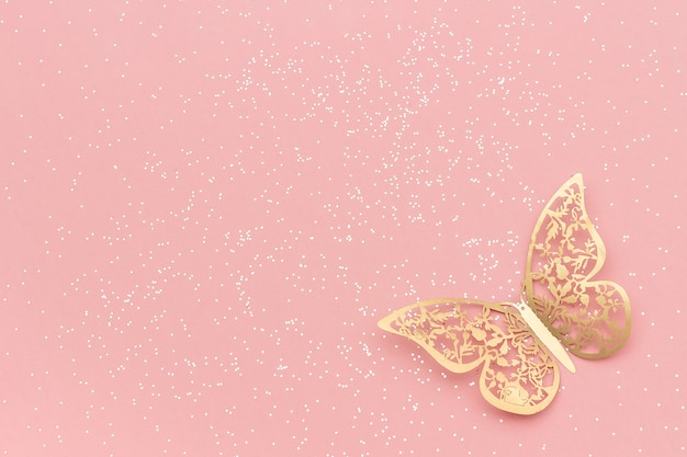 Os sparkles brilham e borboleta do tracery do ouro no fundo na moda pastel cor-de-rosa. Foto Premium