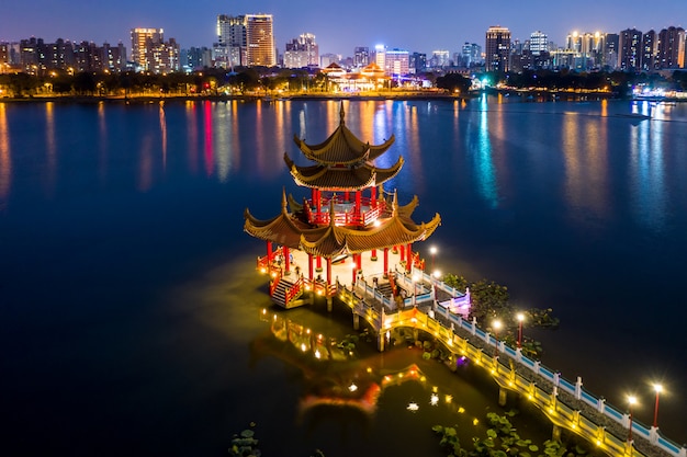 Pagode chinês tradicional decorado bonito com a cidade de kaohsiung no fundo na noite Foto Premium