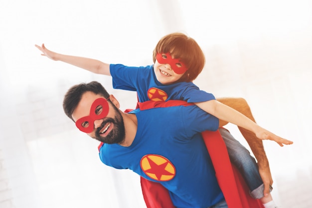 Pai e filho estão vestindo em super-heróis de máscaras de rostos