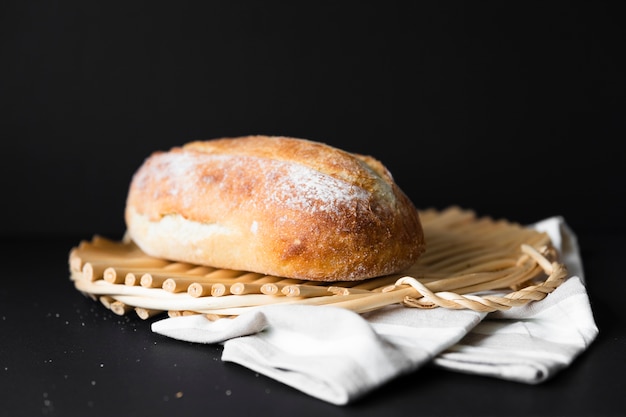 Pão delicioso tamanho inteiro em material de pano e fundo preto Foto gratuita