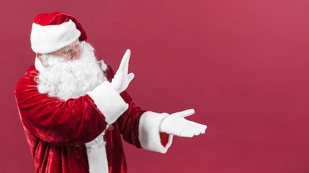 Papai noel em copos mostrando algo com as mãos Foto gratuita