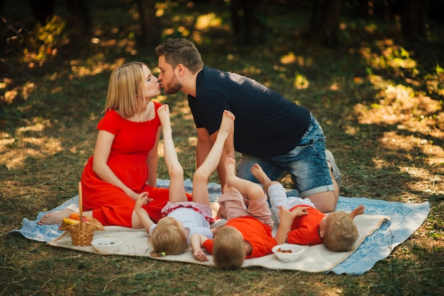 Par, beijando, e, tocando, com, crianças Foto gratuita