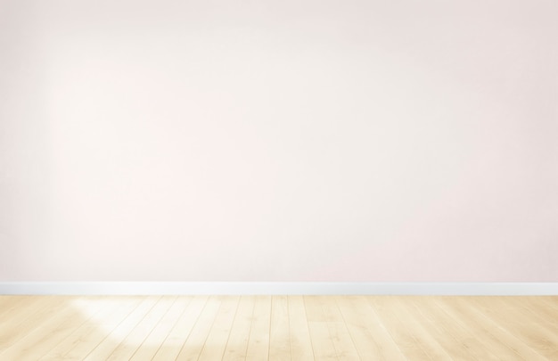 Parede rosa claro em um quarto vazio com um piso de madeira Foto gratuita