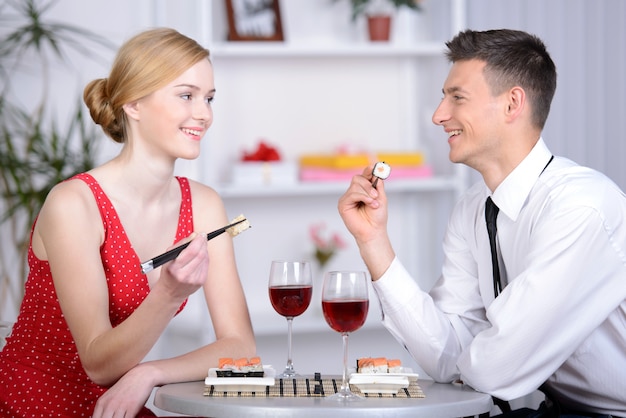 Pares novos bonitos que sentam-se junto no restaurante. Foto Premium