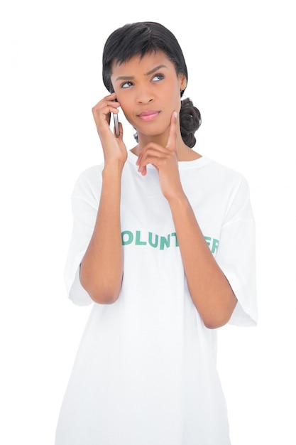 Perguntando voluntário de cabelo preto chamando alguém com seu telefone celular Foto Premium