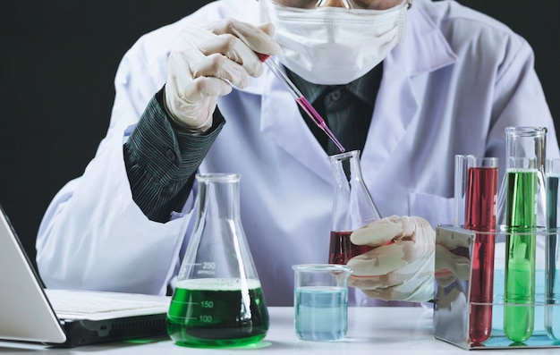 Pesquisador com tubos de ensaio químicos de laboratório de vidro com líquido Foto Premium