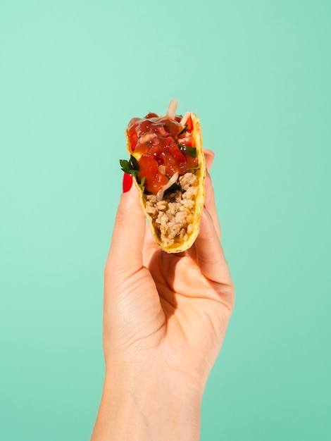 Pessoa de close-up com taco e fundo verde Foto gratuita