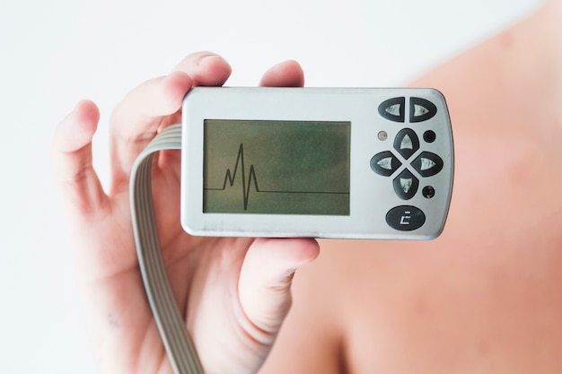 Pessoa, mão, segurando, monitor, cardiograma Foto gratuita