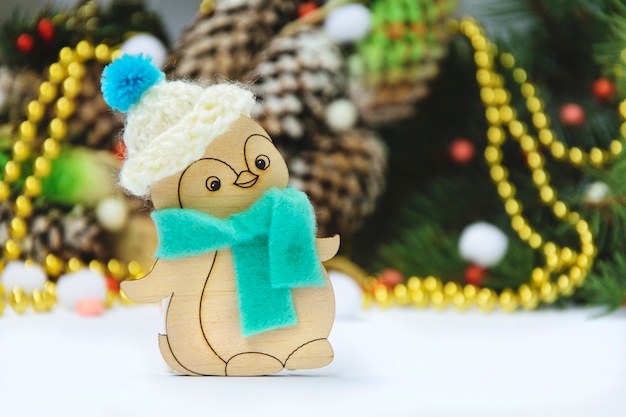 Pinguim de brinquedo de natal de madeira com um chapéu em um fundo temático Foto Premium