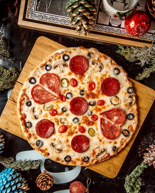 Pizza mista com salsichas, azeitonas e tomate Foto Grátis