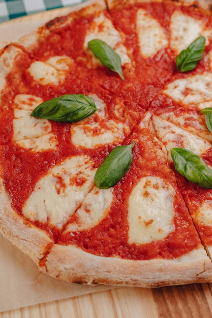Pizza napolitana com presunto, queijo, rúcula, manjericão, tomate polvilhado com queijo Foto Premium