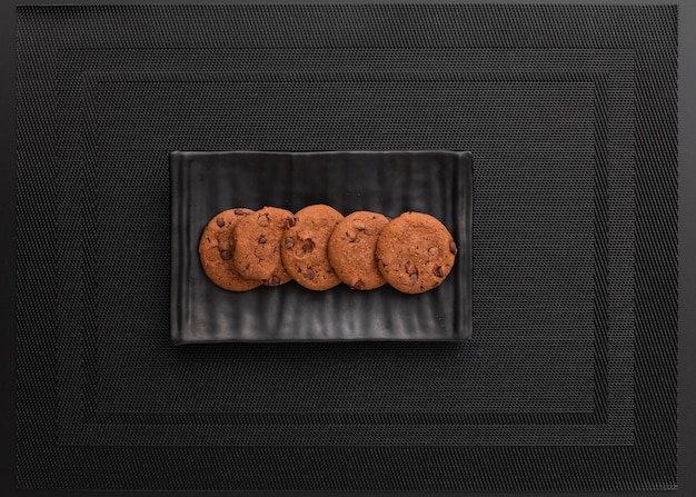 Placa escura com biscoitos em um pano escuro Foto gratuita