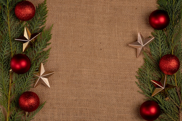 Ramos de carvalho verde com bolas vermelhas de natal e estrelas douradas nos dois lados. Foto gratuita
