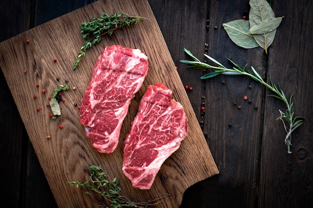 Raw chuck roll bifes premium carne com temperos na placa de madeira, vista superior, stule rústico Foto Premium