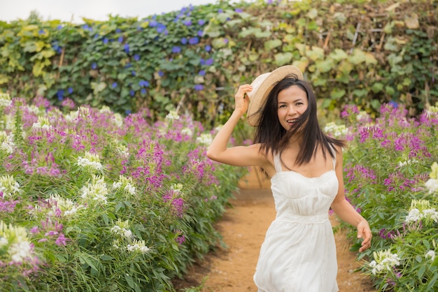Retrato ao ar livre de uma mulher envelhecida média bonita de ásia. garota atraente em um campo com flores Foto gratuita