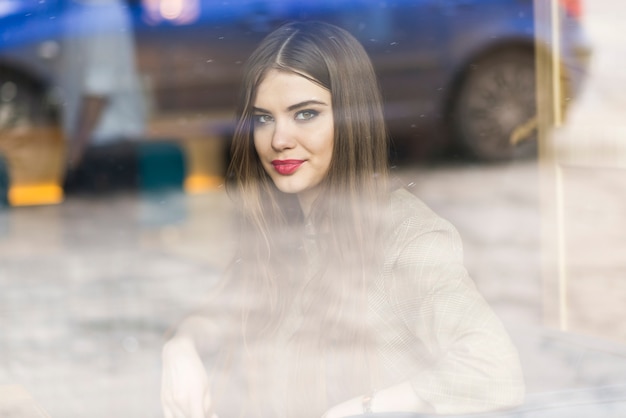 Retrato da mulher através de uma janela | Foto Grátis