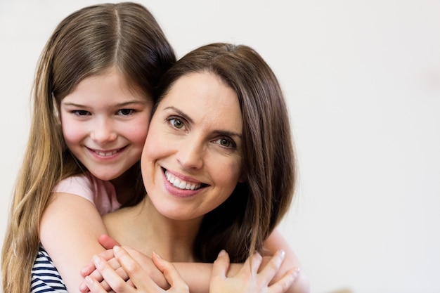 Retrato de mãe e filha que abraçam-se Foto gratuita