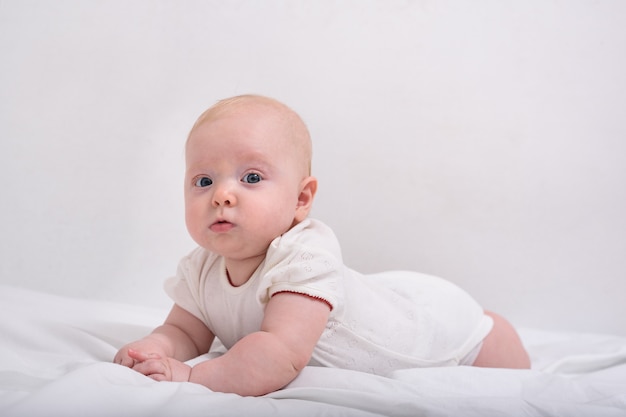 Retrato De Um Bebe Fofo De 3 Meses Deitado Na Cama Bebe Deitado De Barriga Em Lencois Brancos Foto Premium