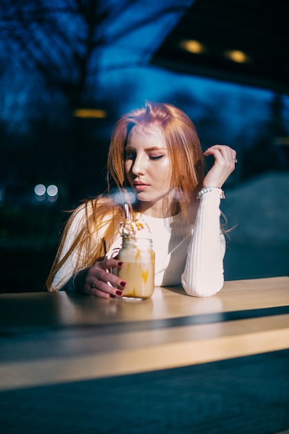 Retrato, de, um, bonito, mulher jovem, sentando, em, café, com, smoothie, jarro Foto gratuita