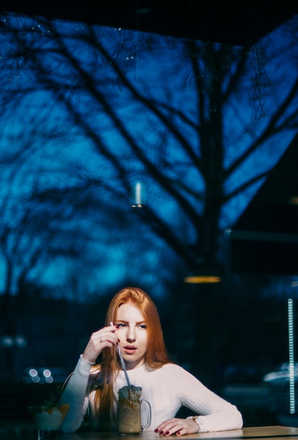 Retrato, de, um, mulher jovem, com, smoothie, jarro, em, caf� Foto gratuita