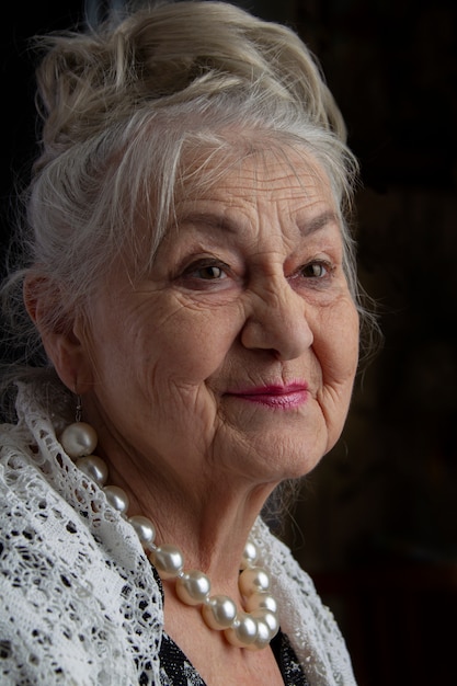 Retrato de uma mulher de noventa anos. linda velhinha. avó de luxo em um  fundo preto. beleza idosa. o aposentado de cabelos grisalhos e bem  preparado. | Foto Premium