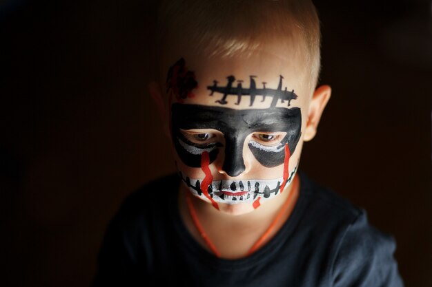 Retrato emocional de um menino com um zumbi assustador no rosto Foto Premium