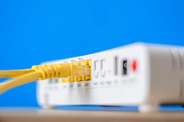Roteador de internet sem fio com cabos de conexão em um fundo azul Foto Premium
