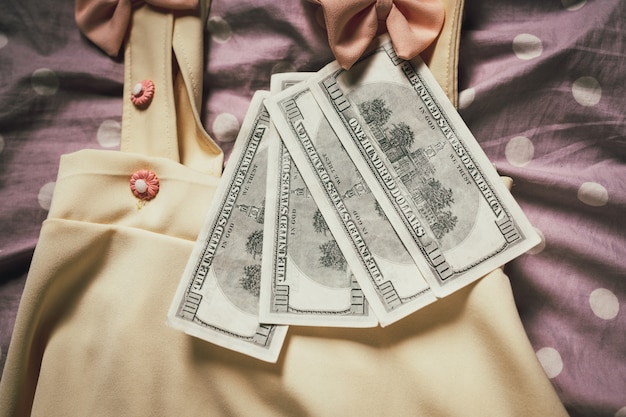 Roupas femininas combinadas com notas de dólar. Foto gratuita