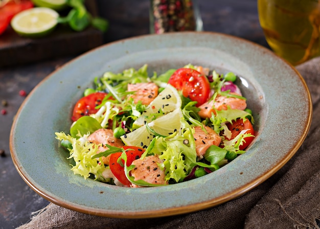 Salada saudável com peixe. salmão assado, tomate, limão e alface. jantar saudável. Foto gratuita