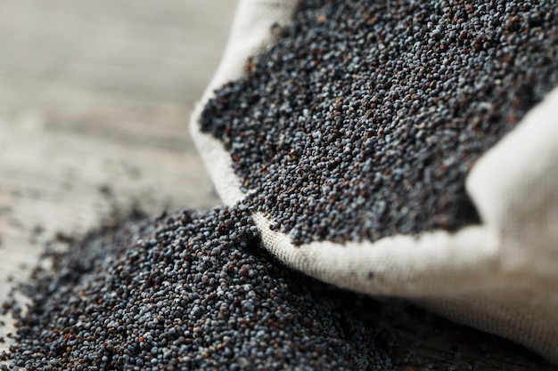 Sementes de papoila em um saco de serapilheira. as sementes saborosas e úteis, ricas em proteínas e óleos. Foto Premium