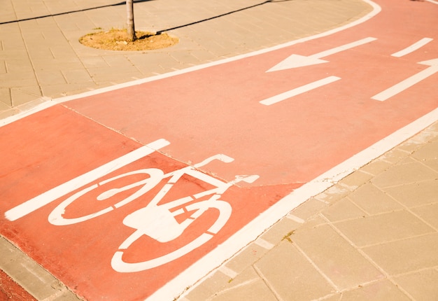 Sinal de bicicleta branca com seta na rua Foto gratuita