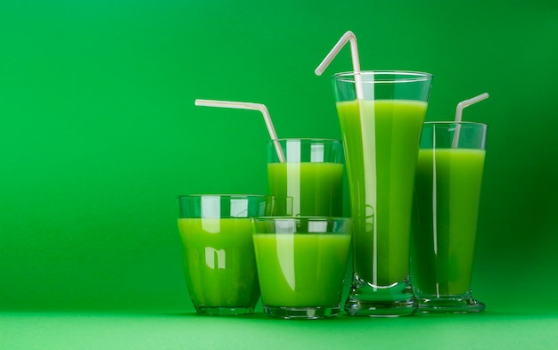 Smoothie verde orgânico, suco de maçã no isolado no fundo verde com espaço da cópia, fresco cocktail de aipo Foto Premium
