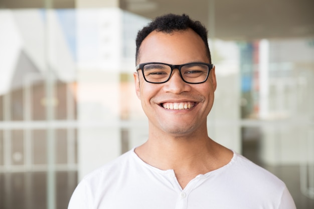 Sorrindo, homem, ficar, predios, olhar, direto, câmera Foto gratuita