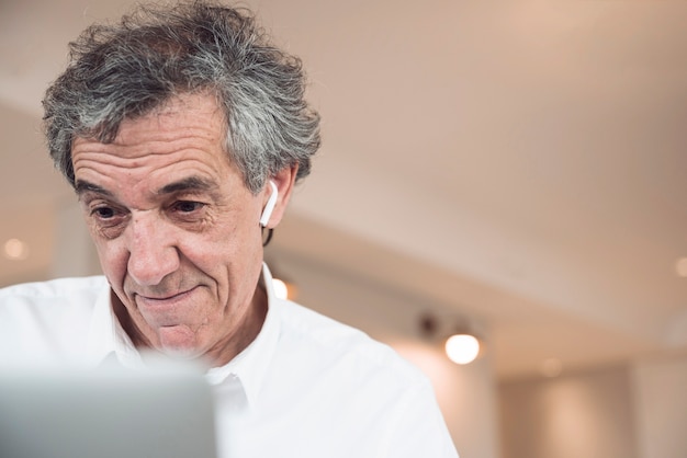 Sorrindo, homem negócios sênior, olhar, laptop Foto gratuita