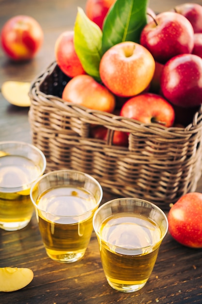Suco de maçãs em vidro com maçã no cesto Foto gratuita