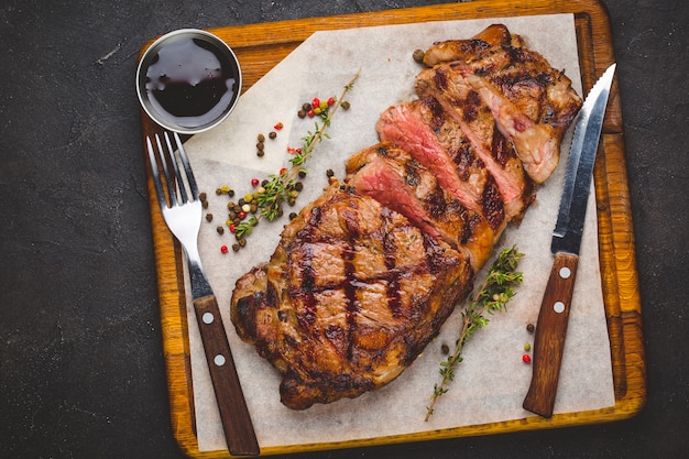 Suculento grelhado grande bife grelhado guarnecido com ervas e sal Foto Premium