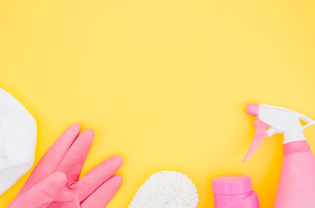 Suprimentos de limpeza-de-rosa e branco em pano de fundo amarelo Foto gratuita