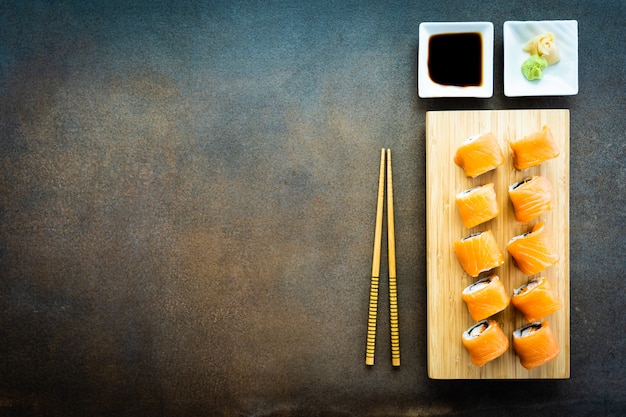 Sushi de carne de peixe salmão roll maki na placa de madeira Foto gratuita