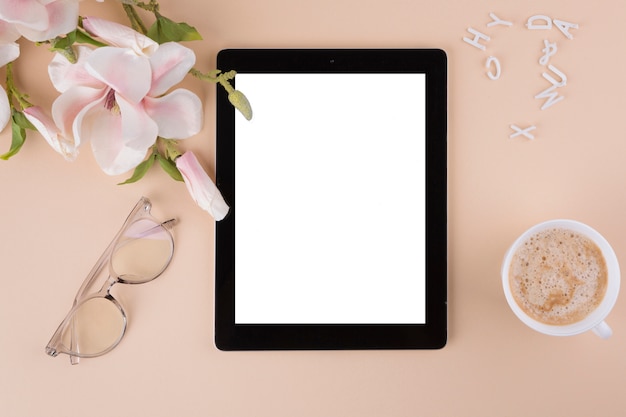 Tablet com xícara de café e flores Foto gratuita