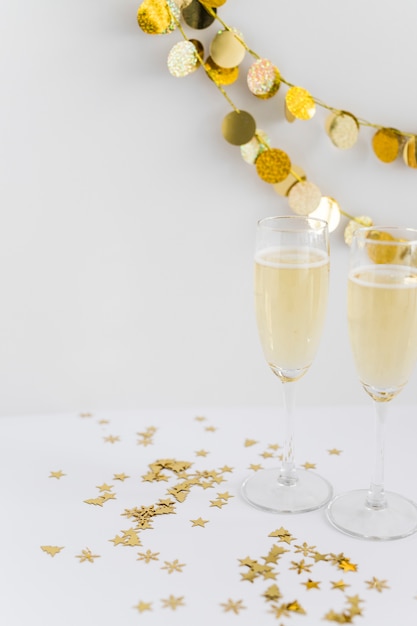 Taças de champanhe com lantejoulas na mesa Foto gratuita