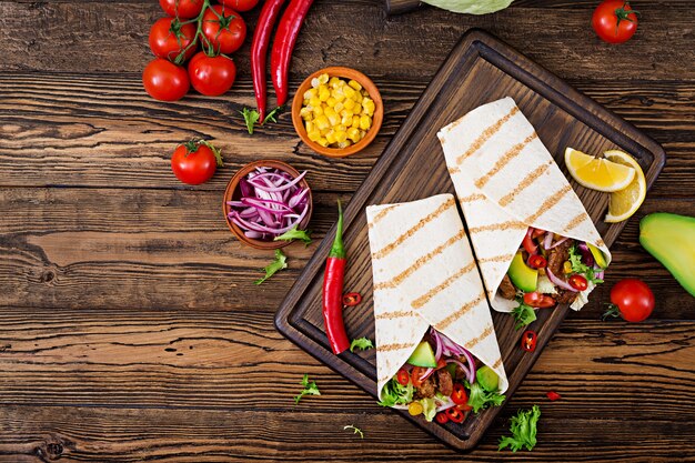 Tacos mexicanos com carne no molho de tomate e na salsa do abacate. lay plana. vista do topo Foto Premium