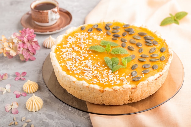 Tarte de abóbora doce americano tradicional decorado com hortelã, gergelim e sementes de abóbora. vista lateral Foto Premium