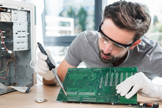 Técnico masculino, reparar, circuito computador, tábua Foto gratuita