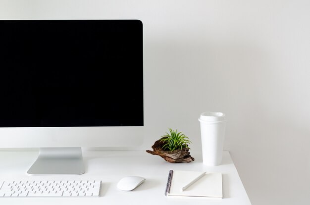Tela de computador pessoal moderna na mesa branca com uma xícara de café. Foto Premium