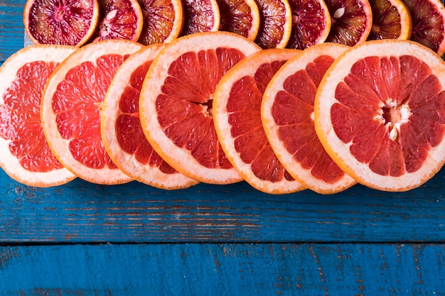 Teste padrão com fatias frescas de toranja, sobre a placa de madeira azul, com espaço da cópia. lay plana. Foto Premium
